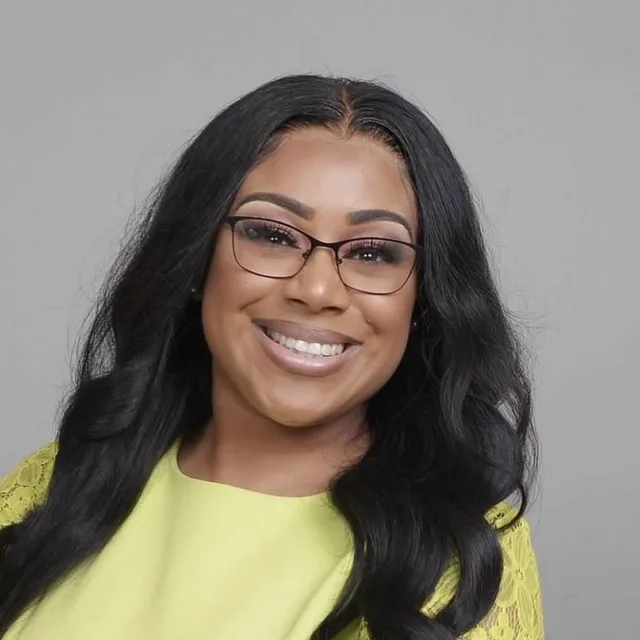 Meshayla Kemp smiling in glasses and a lime-green lace-sleeved top